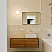 Подвесная деревянная тумба с прямоугольной раковиной и настенным зеркалом в интерьере светлой ванной